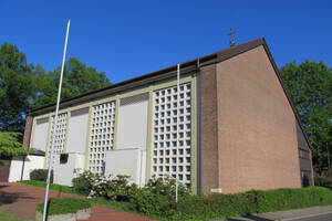 Blick über den bepflanzten Vorplatz auf die Kirche St. Hedwig